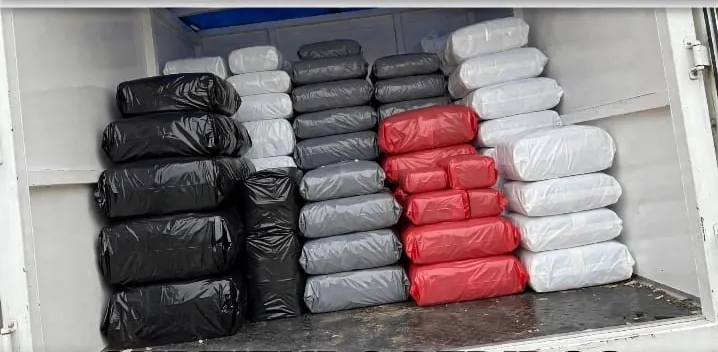 Camioneta cargada con pedidos empacados en negro, gris, rojo y blanco