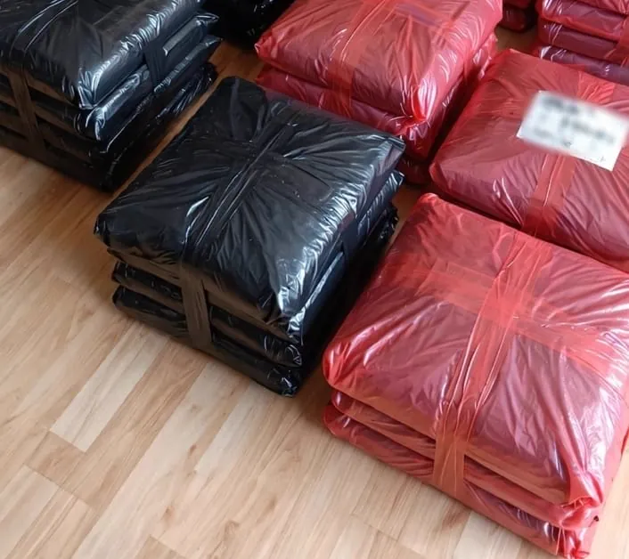 Pedidos empacados en bolsas negras y rojas